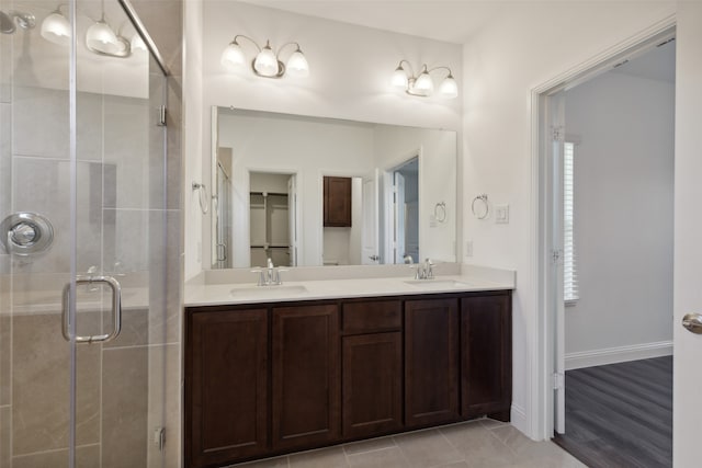 bathroom with hardwood / wood-style floors, a shower with door, and vanity