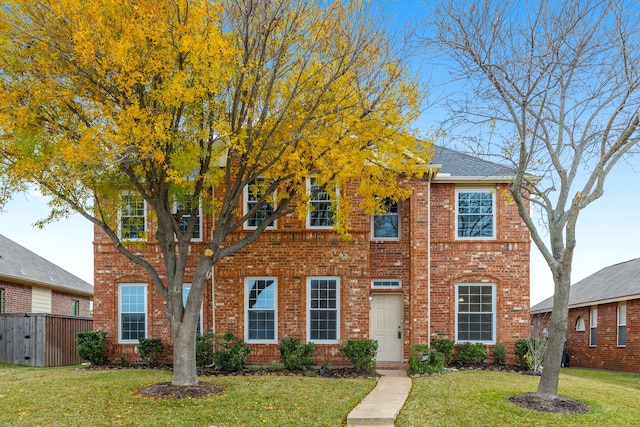 colonial-style house featuring a front yard