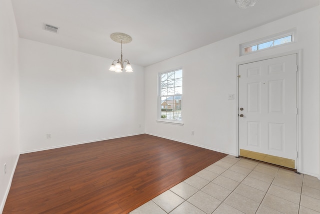 foyer entrance with light hardwood / wood-style flooring and a notable chandelier