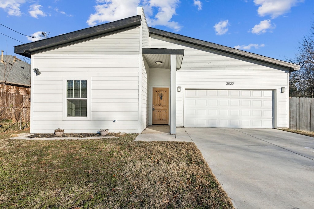 view of front of home with a garage and a front lawn