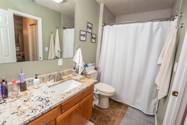 bathroom featuring a textured ceiling, toilet, and vanity