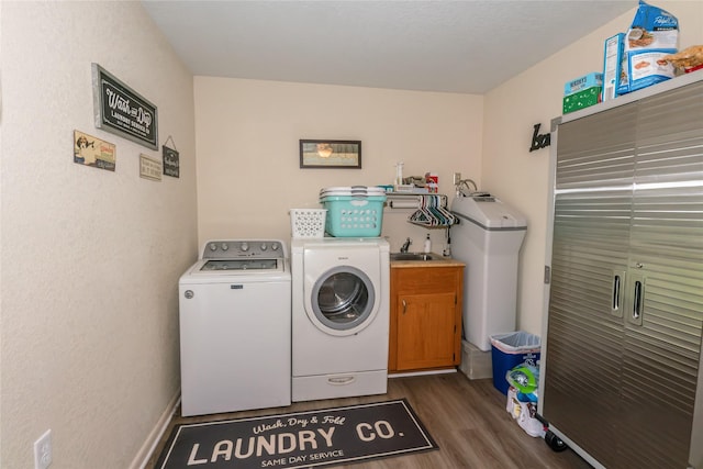 laundry area featuring separate washer and dryer, cabinets, dark hardwood / wood-style flooring, and sink