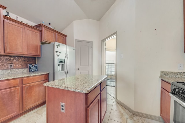 kitchen with tasteful backsplash, appliances with stainless steel finishes, light stone countertops, lofted ceiling, and a center island