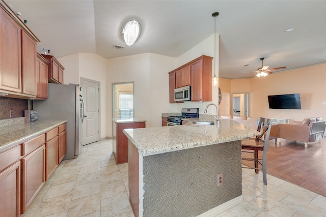 kitchen featuring stainless steel appliances, kitchen peninsula, a kitchen breakfast bar, light hardwood / wood-style flooring, and decorative light fixtures