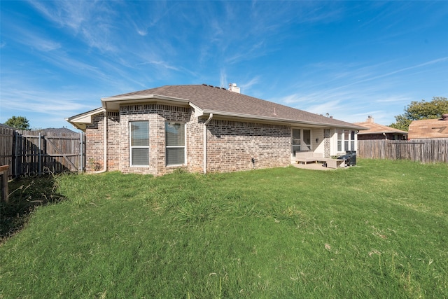 rear view of house featuring a lawn