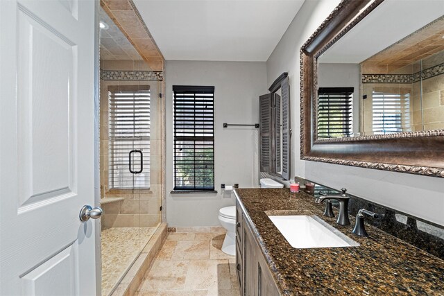 4721 Layla Rd, Arlington, TX 76016 - bathroom with toilet, a stall shower, vanity, stone tile floors, and baseboards