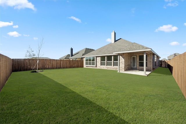 rear view of property featuring a yard and a patio area