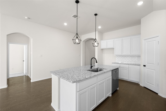 kitchen with dishwasher, an island with sink, sink, white cabinets, and light stone counters