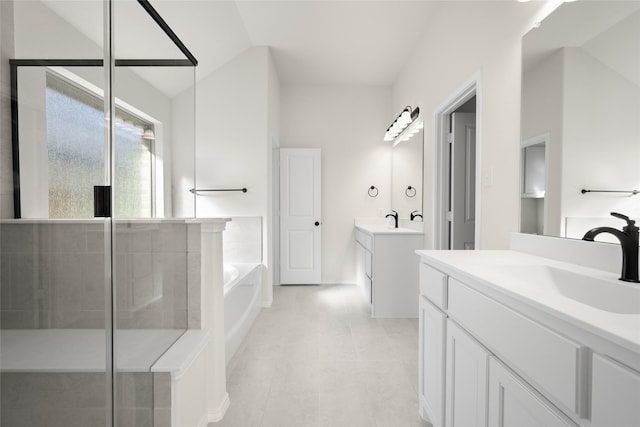 bathroom featuring independent shower and bath, vanity, vaulted ceiling, and tile patterned flooring