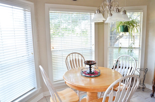 tiled dining space featuring a healthy amount of sunlight and a chandelier