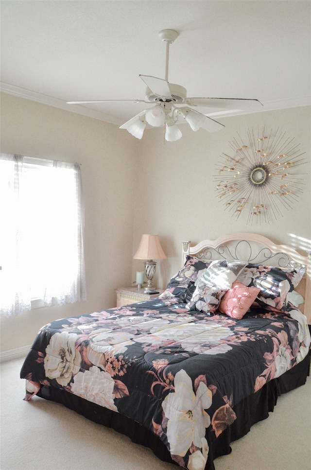 carpeted bedroom with ceiling fan and crown molding