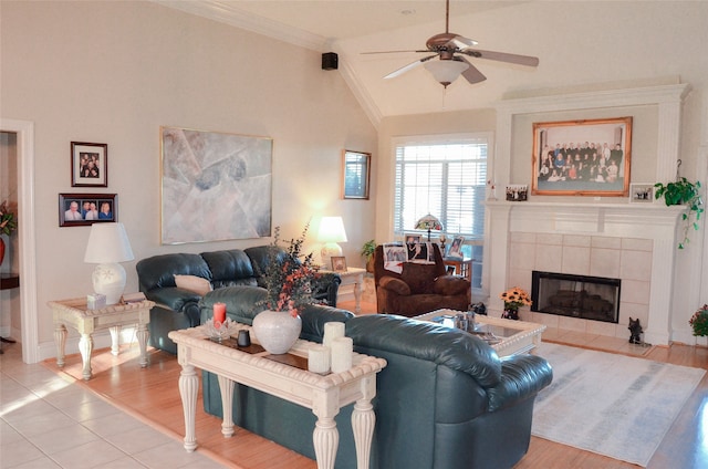 living room featuring ornamental molding, a fireplace, vaulted ceiling, light hardwood / wood-style floors, and ceiling fan