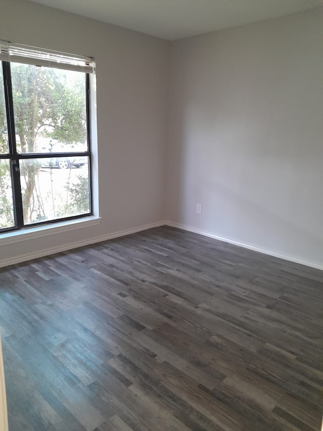 unfurnished room with plenty of natural light and dark hardwood / wood-style floors