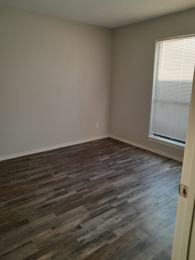 empty room featuring dark hardwood / wood-style flooring and a textured ceiling