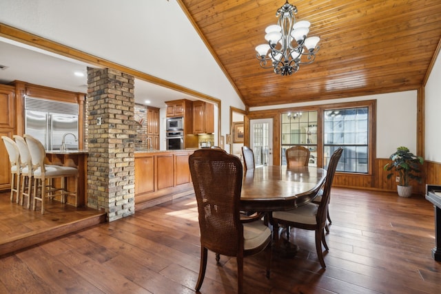 dining space with wooden ceiling, dark hardwood / wood-style floors, a notable chandelier, wooden walls, and ornate columns