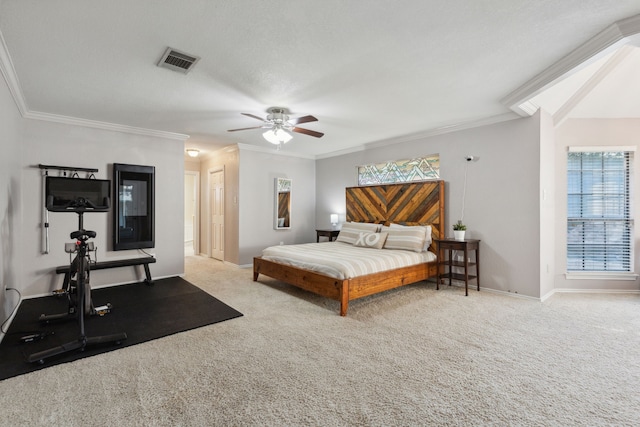 bedroom featuring ornamental molding, a textured ceiling, light carpet, and ceiling fan