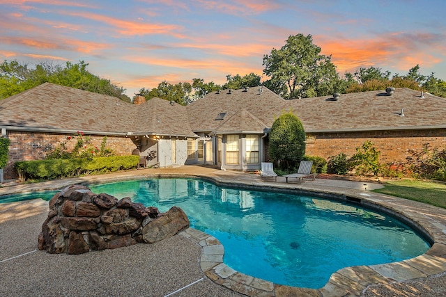 pool at dusk with a patio