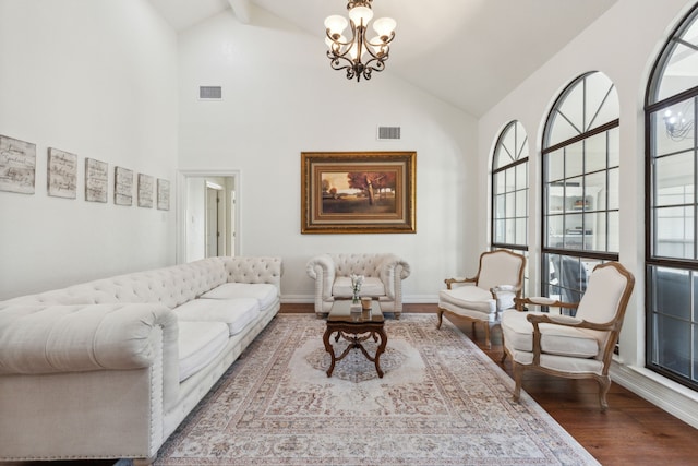 living room featuring high vaulted ceiling, wood-type flooring, and a notable chandelier