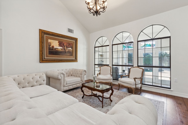 living room featuring hardwood / wood-style flooring, a chandelier, and high vaulted ceiling