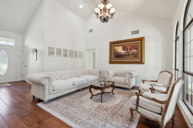 living room with high vaulted ceiling, dark wood-type flooring, and an inviting chandelier