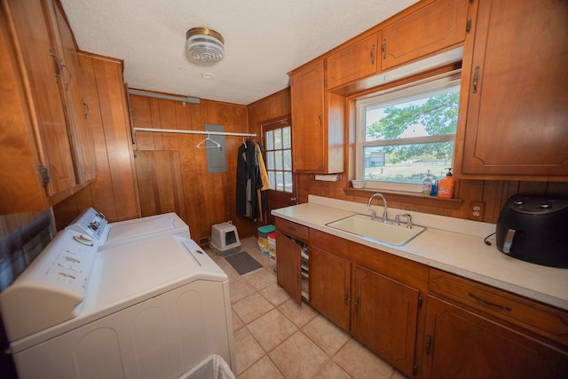 washroom with separate washer and dryer, cabinets, wood walls, a textured ceiling, and sink