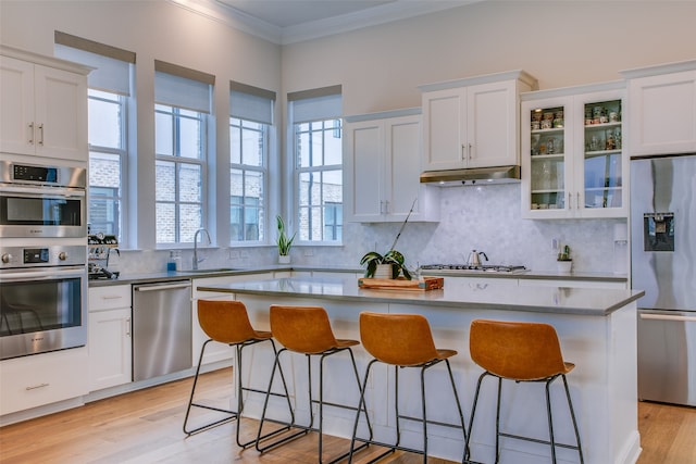 kitchen featuring a center island, white cabinets, a healthy amount of sunlight, and stainless steel appliances