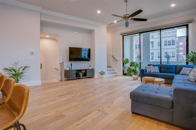 living room with light hardwood / wood-style floors, crown molding, and ceiling fan