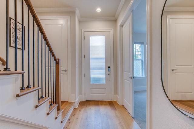 foyer entrance featuring light wood-type flooring and crown molding