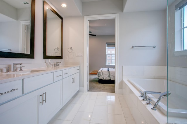 bathroom with vanity, tiled bath, and tile patterned flooring