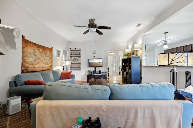 living room featuring dark wood-type flooring, ceiling fan, and crown molding