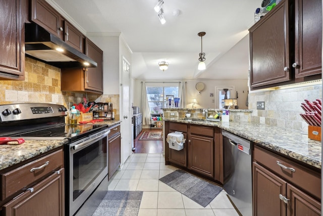 kitchen featuring appliances with stainless steel finishes, light tile patterned floors, light stone countertops, hanging light fixtures, and kitchen peninsula