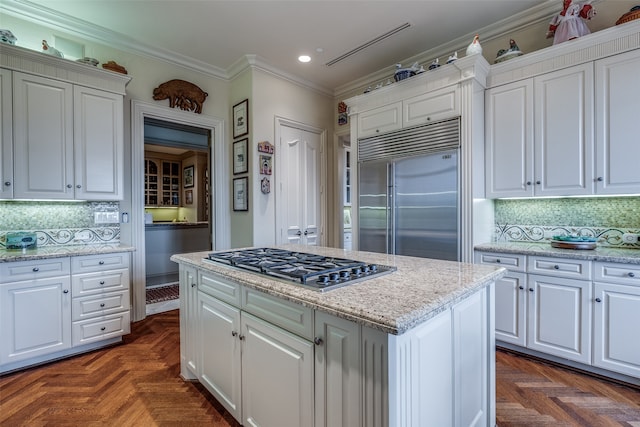 kitchen featuring white cabinetry, appliances with stainless steel finishes, decorative backsplash, and dark parquet floors