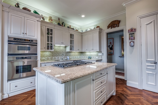 kitchen with white cabinetry, backsplash, light stone counters, and stainless steel appliances