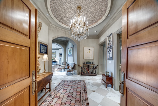 foyer entrance featuring a chandelier, crown molding, and a tray ceiling