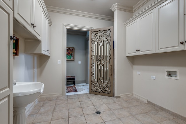 clothes washing area featuring hookup for a washing machine, cabinets, light tile patterned floors, and ornamental molding