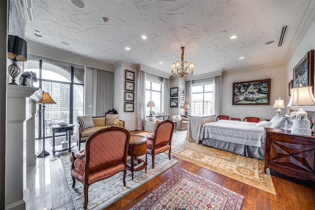 bedroom with ornamental molding, a textured ceiling, hardwood / wood-style flooring, and a chandelier