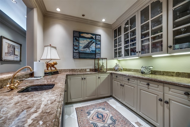 kitchen with dark stone countertops, gray cabinetry, sink, and ornamental molding