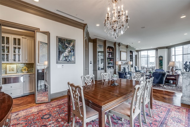 dining room featuring a chandelier, parquet flooring, and ornamental molding