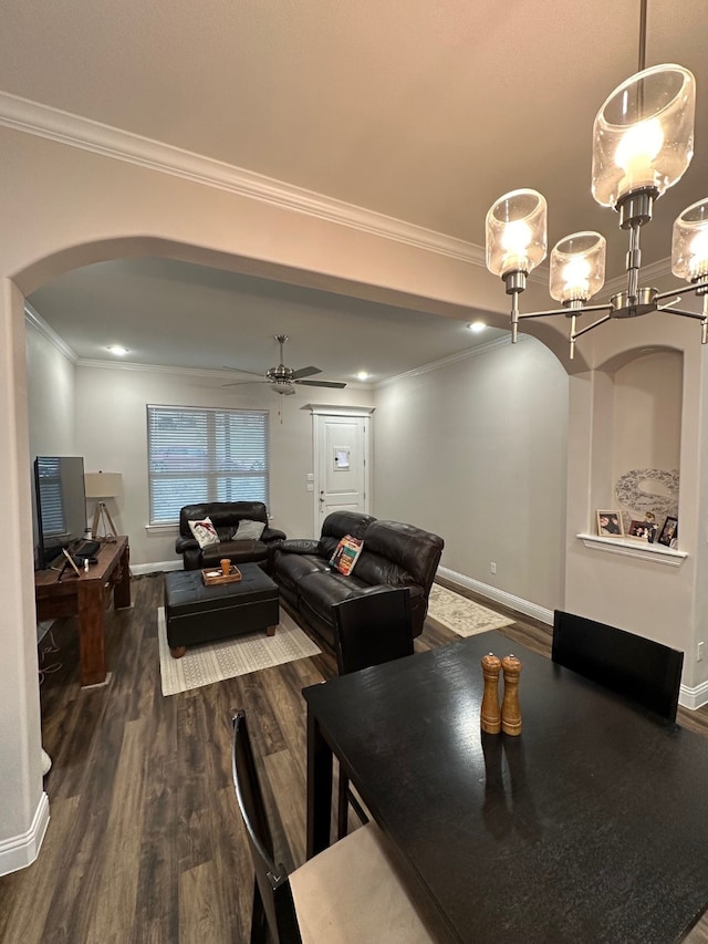 dining area featuring ceiling fan with notable chandelier, dark hardwood / wood-style flooring, and ornamental molding