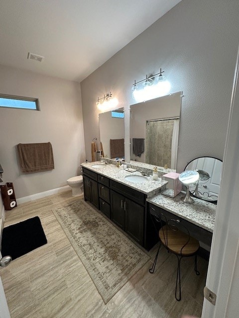 bathroom featuring toilet, vanity, and hardwood / wood-style flooring