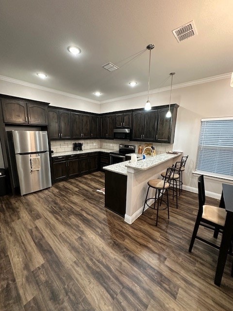 kitchen featuring stainless steel appliances, hanging light fixtures, a breakfast bar area, dark hardwood / wood-style floors, and light stone countertops