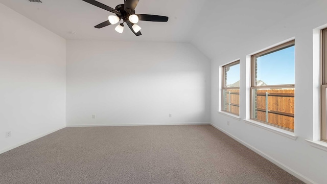 empty room featuring a ceiling fan, carpet, vaulted ceiling, and baseboards