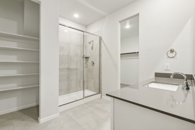 bathroom featuring tile patterned flooring, vanity, and walk in shower