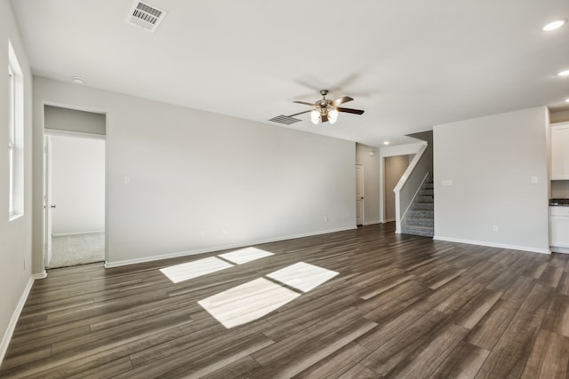 unfurnished living room with ceiling fan and dark wood-type flooring