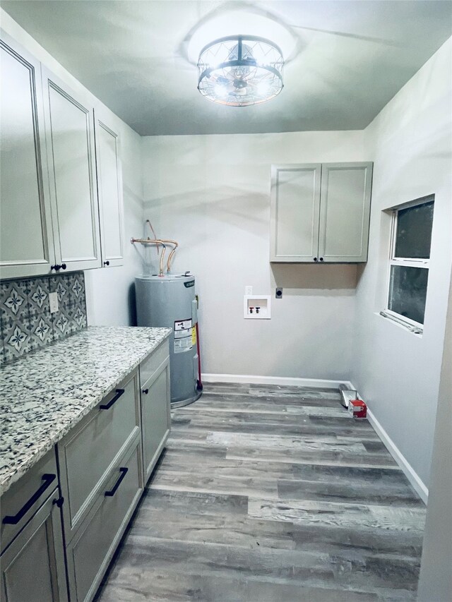 clothes washing area with electric water heater, hookup for a washing machine, wood finished floors, cabinet space, and electric dryer hookup