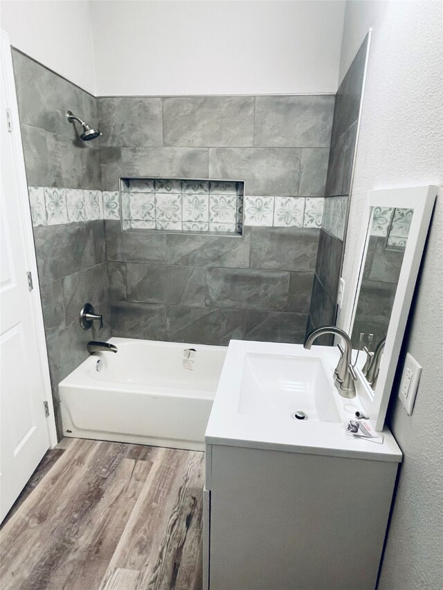 full bath featuring vanity, wood finished floors, and tub / shower combination