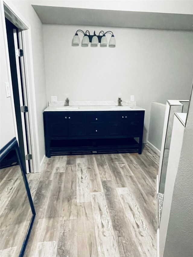 bathroom featuring a sink, baseboards, and wood finished floors