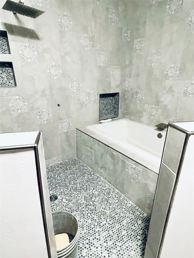 bathroom with tile walls, a bath, and tiled shower