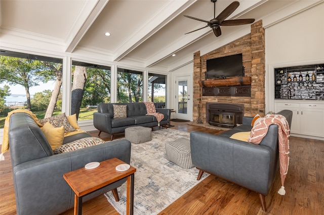 living room featuring ceiling fan, a wealth of natural light, wood-type flooring, and vaulted ceiling with beams