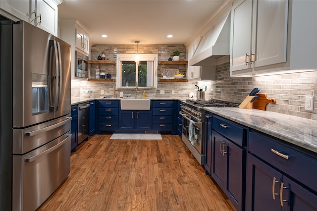 kitchen with white cabinets, light wood-type flooring, appliances with stainless steel finishes, and sink